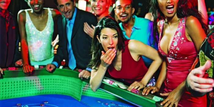 Group of People Standing Next To A Gaming Table