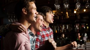 Three friends watching a game at a bar. Three friends watching a game at a bar.