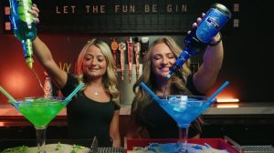 Two women pouring drinks into cocktail glasse
