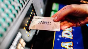 Caesars Rewards card going into a machine.