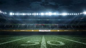 Football field at night with banner that read's "Football Arena"