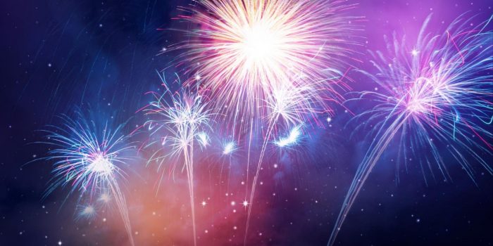 Fireworks lighting up a purple and blue sky at night Fireworks lighting up a purple and blue sky at night