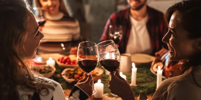 Photo of nice joyful people drinking wine and having Christmas dinner