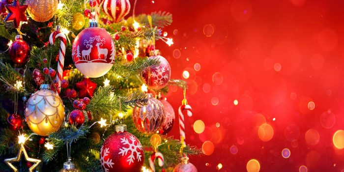 A beautifully decorated Christmas tree on a red background