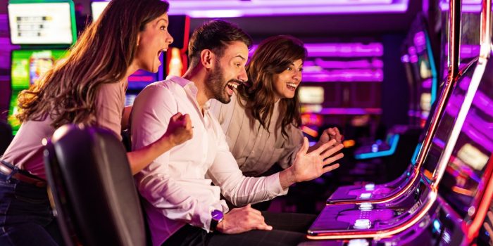 Group of friends celebrating at a casino slot machine.