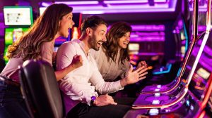 Group of friends celebrating at a casino slot machine.