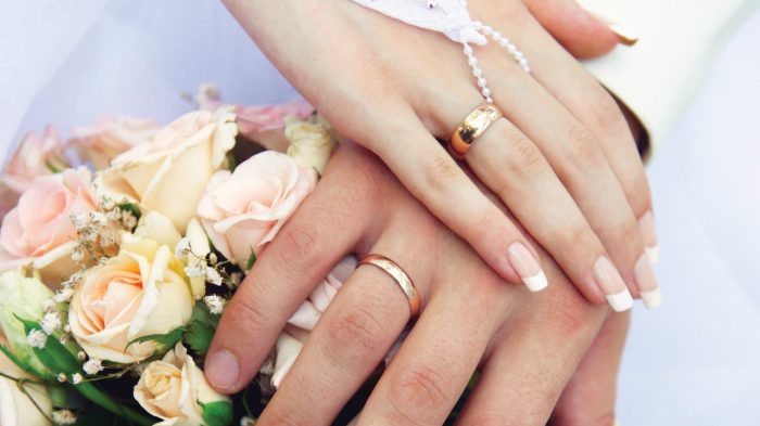 Couple showing wedding rings.