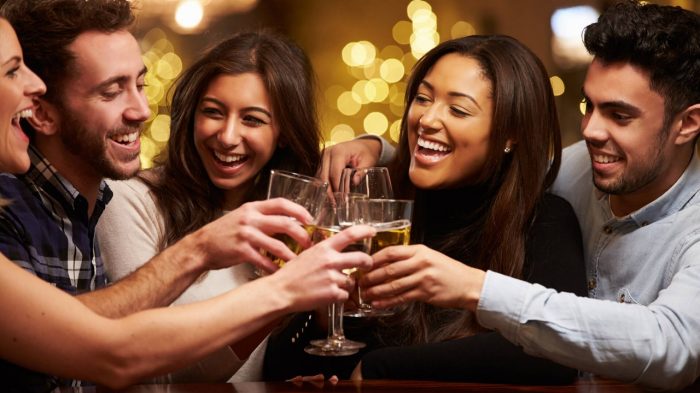 group of five friends cheering drinks