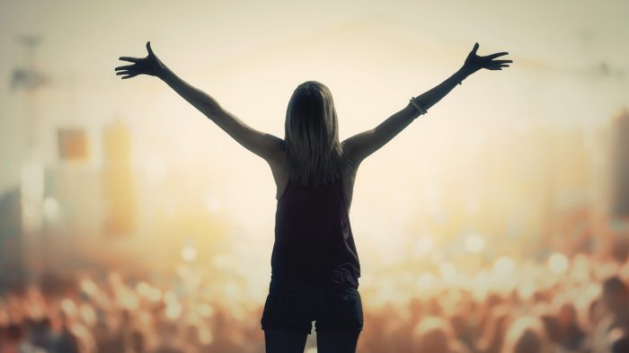 Woman on stage in front of a crowd.