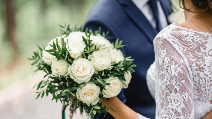 Couple hugging and bride with bouquet in her hand.
