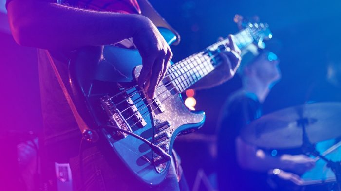 Close up on person playing a guitar.