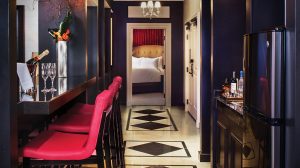 View Inside The Cromwell Gallery Suite Kitchen Area Showing Beautiful Flooring, A Refrigerator, And Bar Stools Against Counter