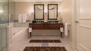Interior view of restroom with double sink and bathtub