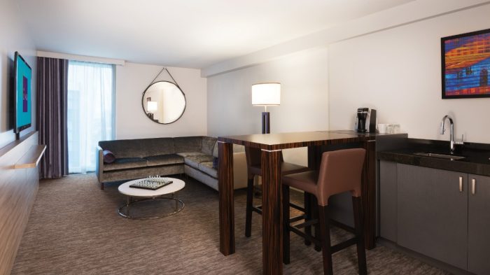 Living room with large screen television, couches and high top dining table