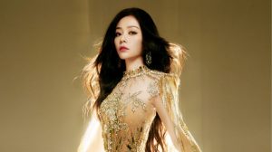 Jane Zhang against a golden backdrop in a beaded dress