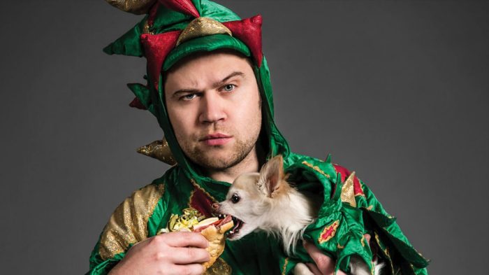 Piff the Magic Dragon Looking Into Camera While Mr. Piffles Eats A Hot Dog