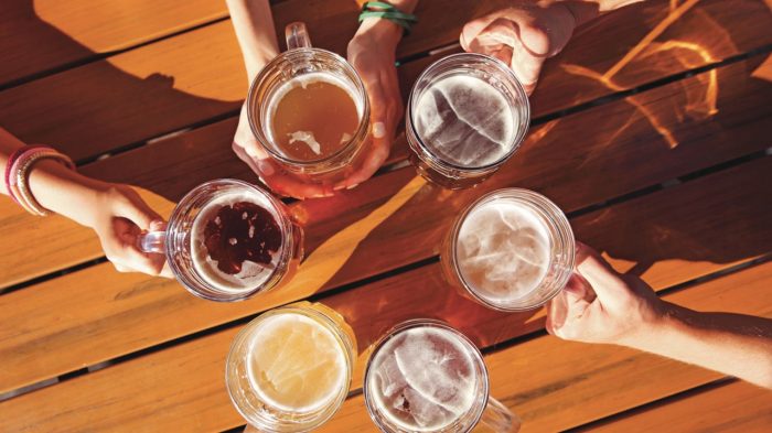 Looking down on large glasses of draft beer being held to form a circle