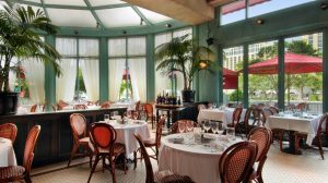 View Into Mon Ami Gabi's Restaurant Dining Area Showing Clothed Tables, Wicker Chairs, And Set Table Ware From Inside The Paris Hotel Las Vegas