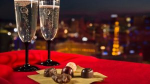 View Of Two Champagne Glasses Next To A Napkin Full Of Chocolates, With Las Vegas Strip In The Back Ground