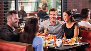 Image of a group of people enjoying food and drinks at Guy Fieri's Las Vegas Kitchen & Bar