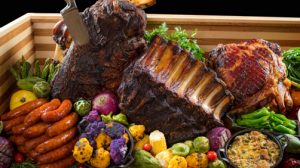 Feast of ribs, sausages, fresh vegetables and a ham