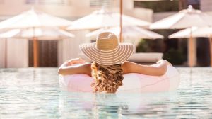 A woman floating in a pool on a pool tube view from behind A woman floating in a pool on a pool tube view from behind