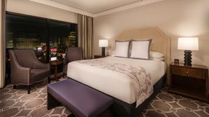 Night shot of Caesars Palace Augustus suite with modern design featuring a king bed and city view