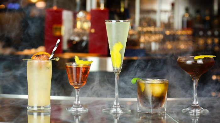 Five different cocktails on a bar.