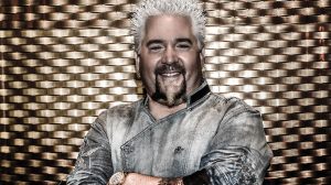 Guy Fieri posing with his arms folded.