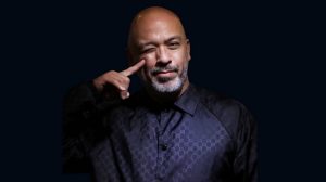 Jo Koy in a blue button down shirt.