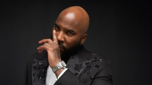 Jeezy in a black suit and wearing a watch