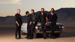 Old Dominion standing in front of an old convertible in the desert.
