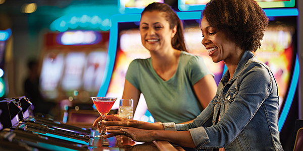Women with drinks playing slots