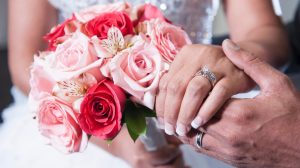 Photo Of Bride And Groom’s Holding Hands Displaying Their Floral Arrangement And Wedding Rings Photo Of Bride And Groom’s Holding Hands Displaying Their Floral Arrangement And Wedding Rings