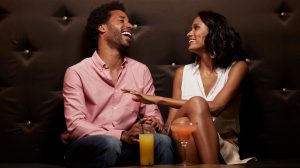 Couple sitting at a booth and having drinks.
