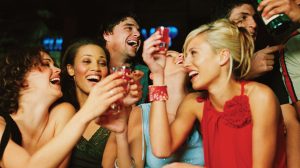 A group of people doing shots in a bar.