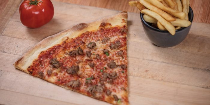 Close Up of Sausage Pizza, A Tomato, And French Fries